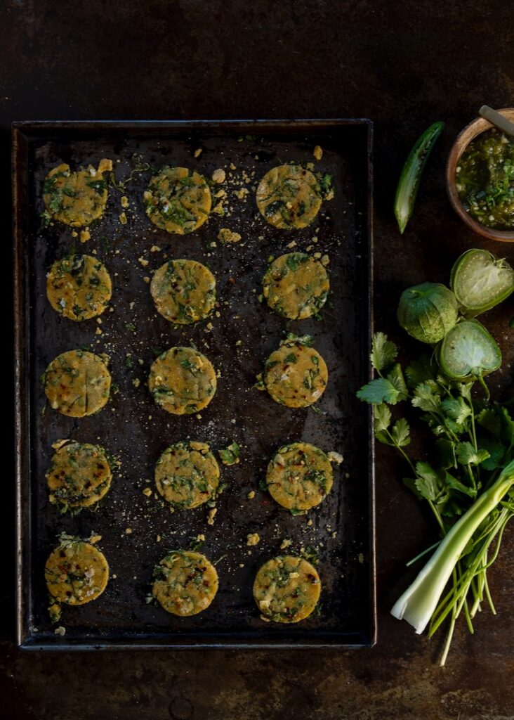 A picture of small Passover crackers in a muffin tin beside fresh produce.