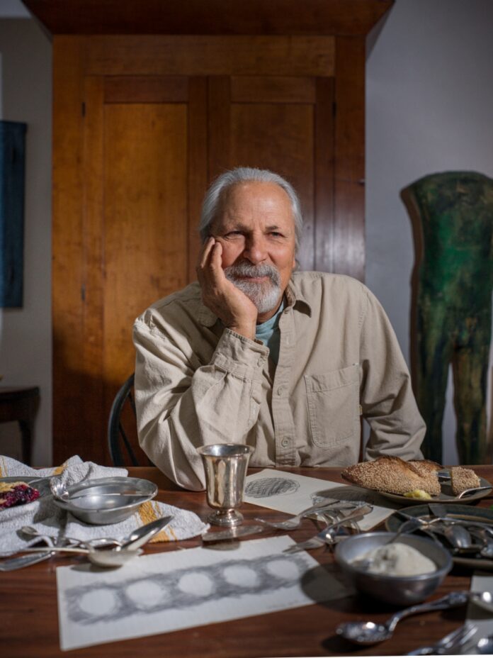 Antique collector Patrick Mehaffy examining a piece of historical American coin silver cutlery through a magnifying loupe.