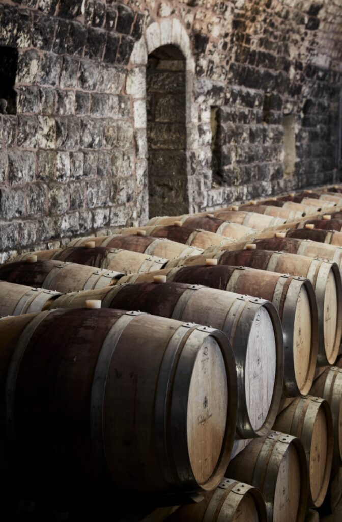 Rows of oak wine barrels aging in a historic stone cellar at Chateau Musar in Lebanon.