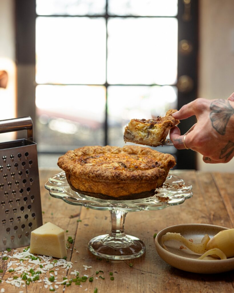 A rustic, savory afternoon tea spread featuring golden-brown scones with dill and cheese served on a patterned plate in a light-filled Santa Fe home.