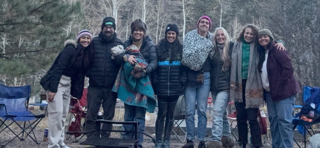 A line up volunteers stand in winter clothing outside.