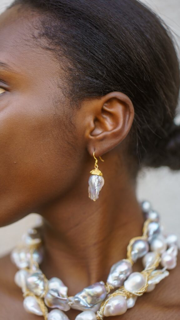 Crystal-like dangle earring on a woman with silver pearls.