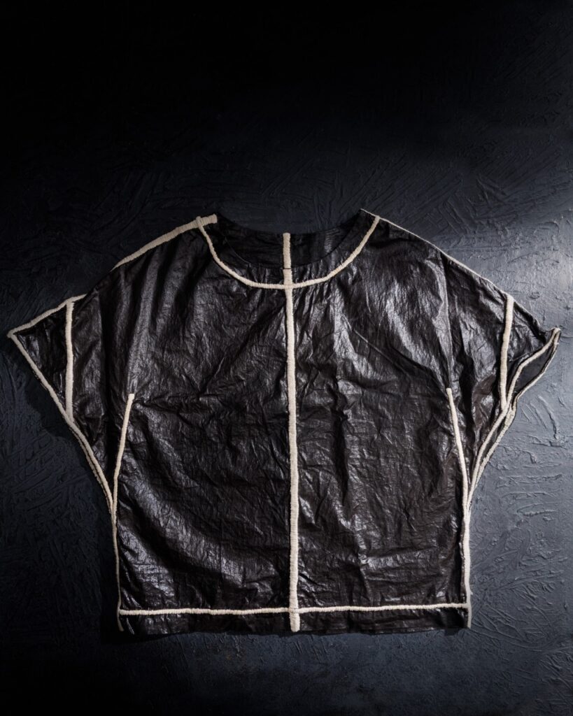 A t shirt with white lines framing its outside and one down the middle.