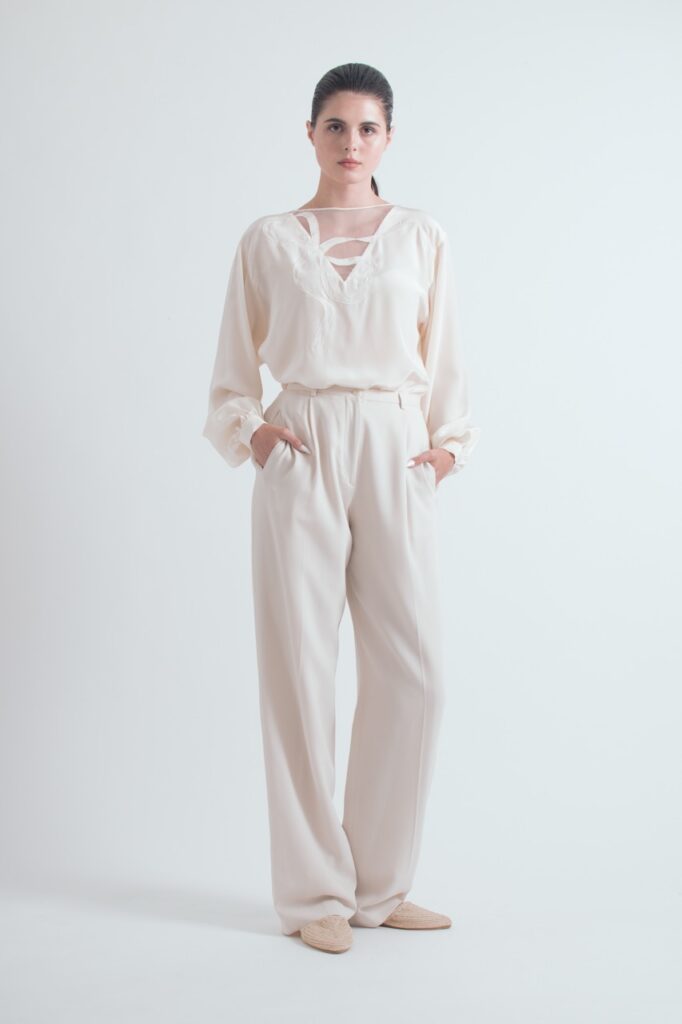 A woman in white long pants and a white long sleeve blouse.