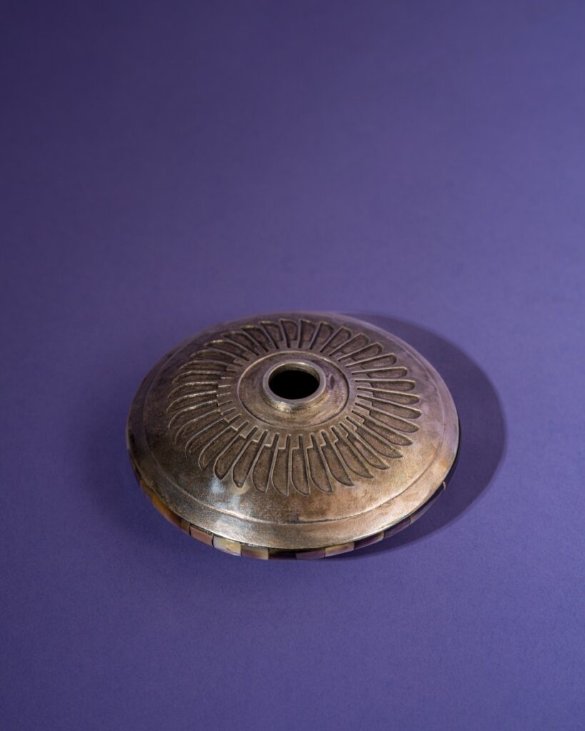 An intricate contemporary seed bowl crafted by Connie Tsosie Gaussoin in 2006, featuring sterling silver, gold accents, and a mother-of-pearl center inlay.