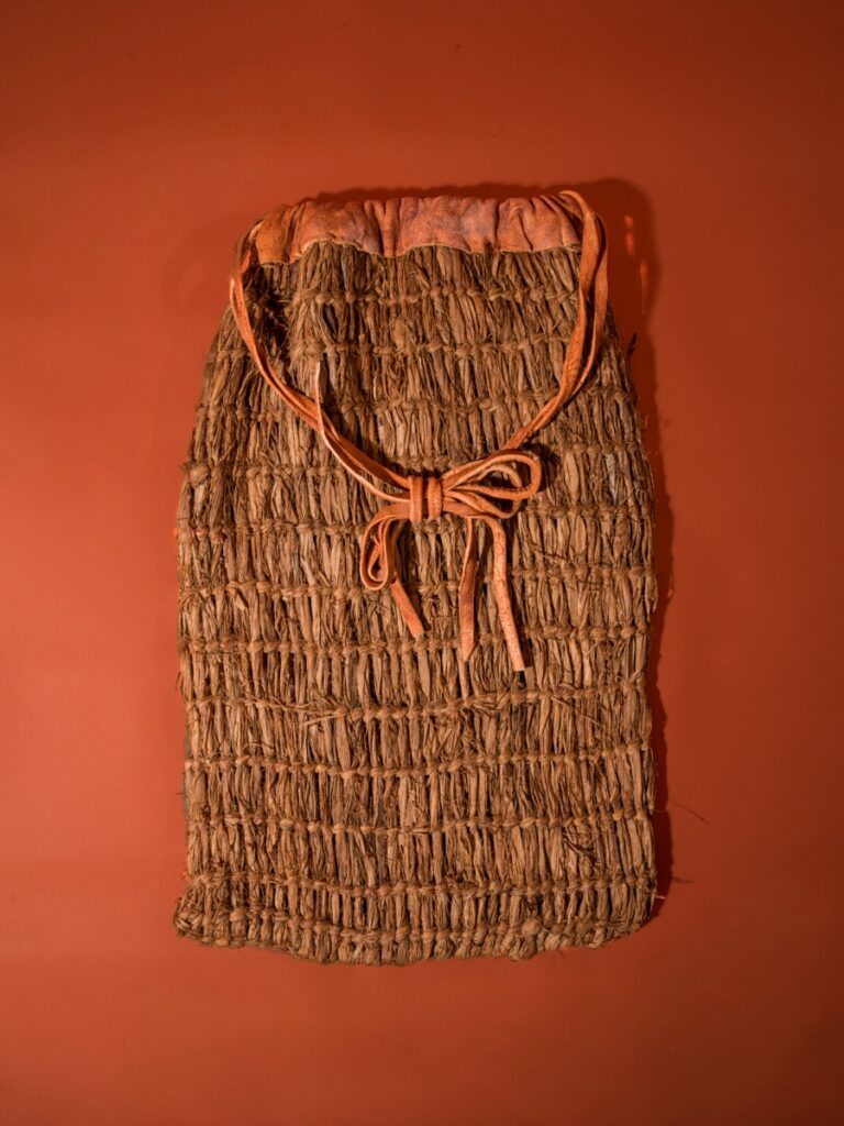 A traditional Moapa Band of Paiutes woven bag created by Everett Pikyavit using cliffrose bark and brain-tanned leather, featuring natural dyes and intricate craftsmanship.