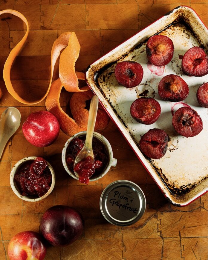 Plum and Pink Grapefruit Jam TABLE Magazine A silver tray of pink grapefruits and plums beside three jars of plum and pink grapefruit jam.
