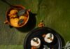 Sage Panna Cotta with Peach Sorbet and Honeycomb Crumble A black plate with three sage panna cottas next to a preach sorbet.