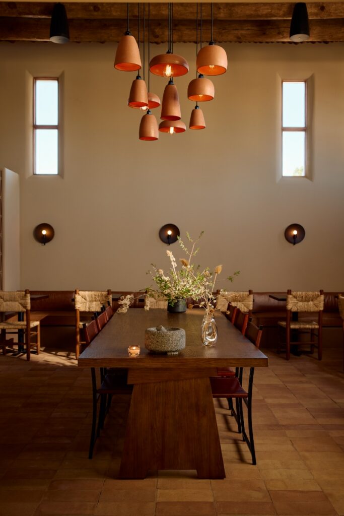 An art-centric guest room at Hotel Willa in Taos, featuring mid-century modern furniture and regional artwork.