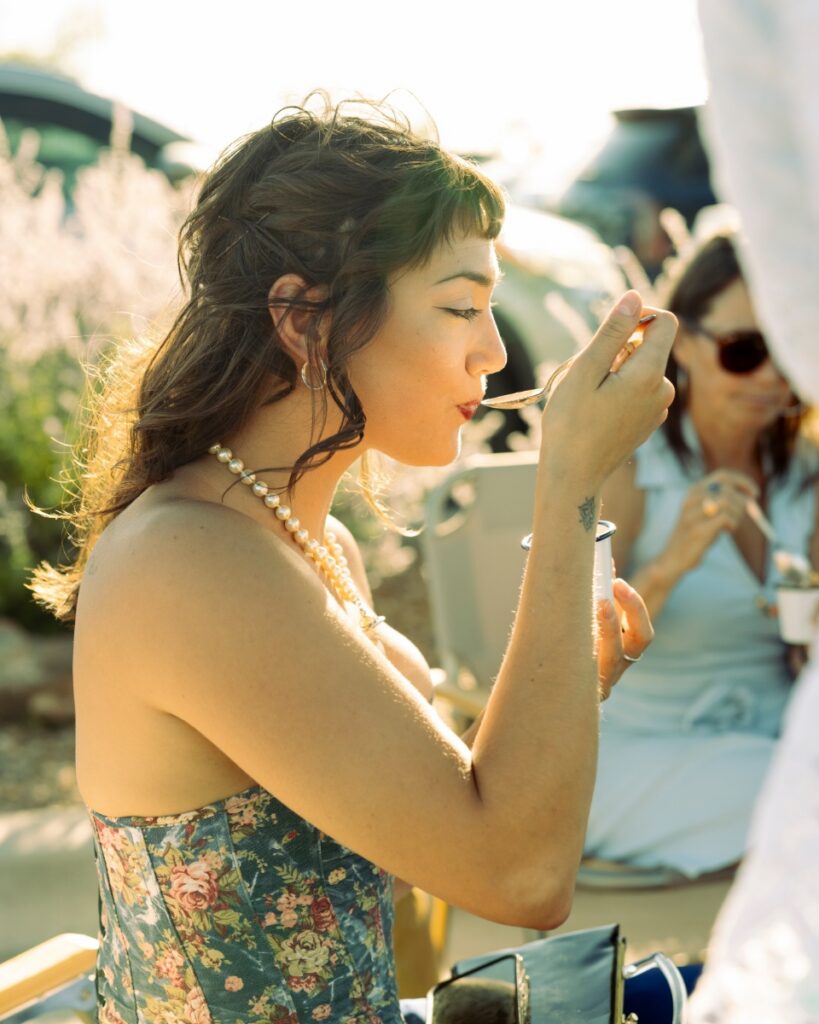 A guest in a floral corset and pearls enjoying a tailgate supper at the Santa Fe Opera.