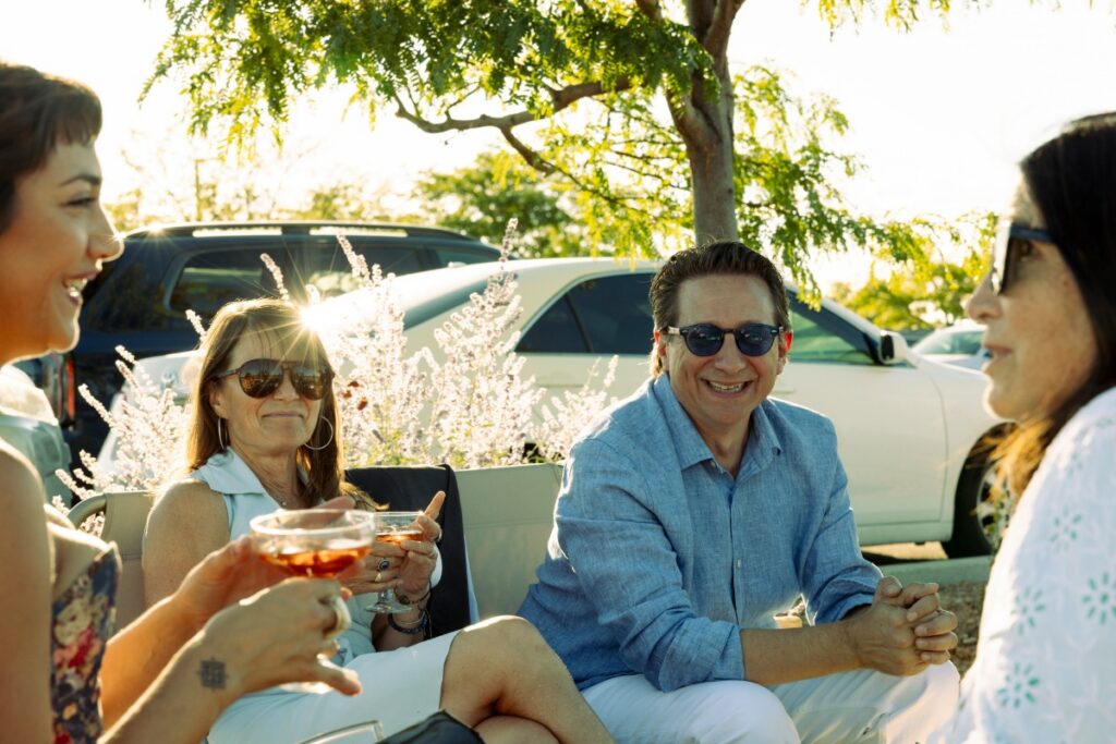 Contributors of TABLE Magazine laughing and enjoying rosé wine during an outdoor opera tailgate in Santa Fe.