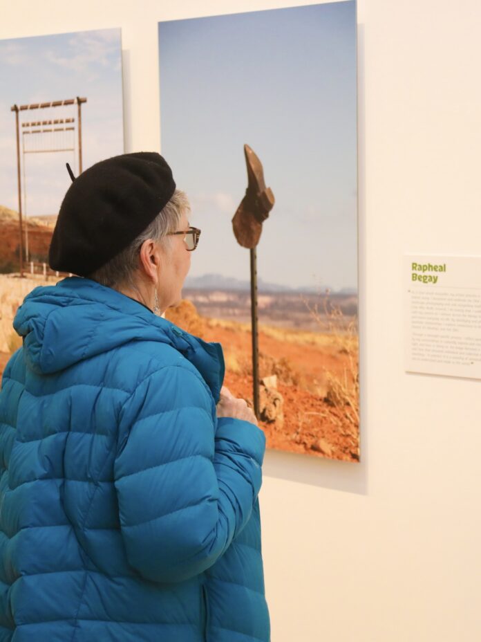 The Museum of Arts and Culture Andres Salazar Photography TABLE Magazine 1 A women in a blue coat and black beret looking at art at the Museum of Arts and Culture in New Mexico.