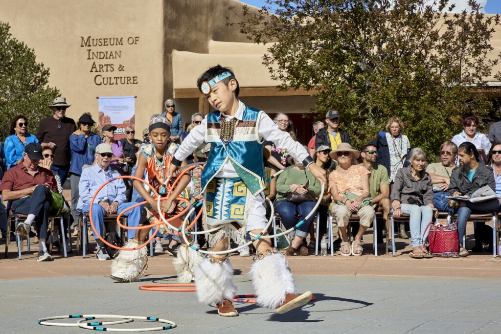 A family-friendly event of a child performing outside The Museum of Indian Arts and Culture in New Mexico