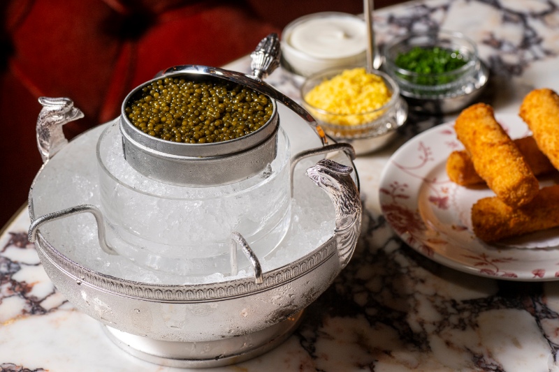 Golden Ossetra caviar served with traditional accompaniments at The Portrait Bar, reflecting the hotel's luxury dining experience.