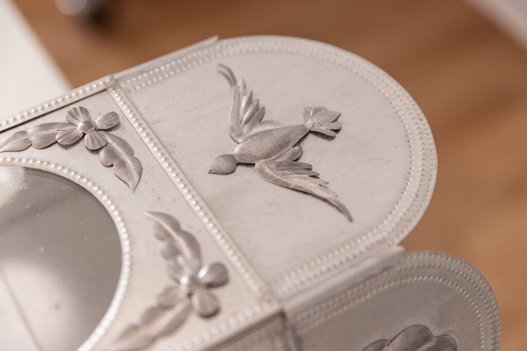 A bird carved on a piece of tin.