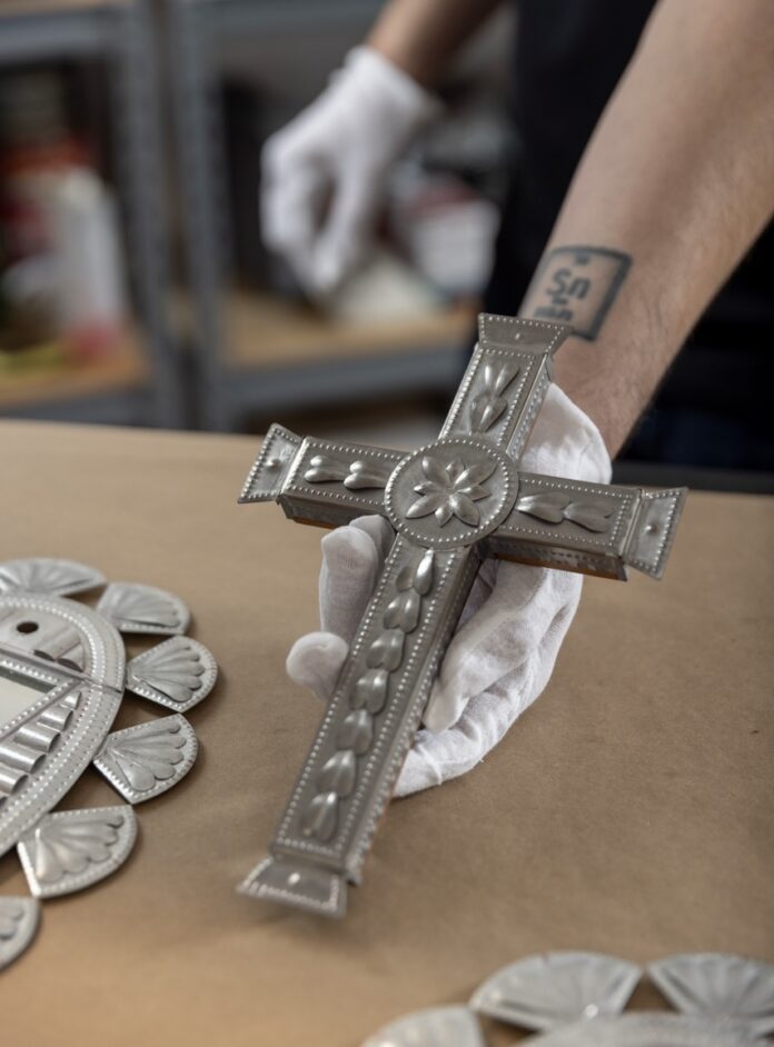 A tin cross with small detail embellishments.