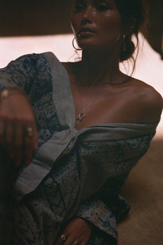 A woman in a button up top hanging off her shoulder.