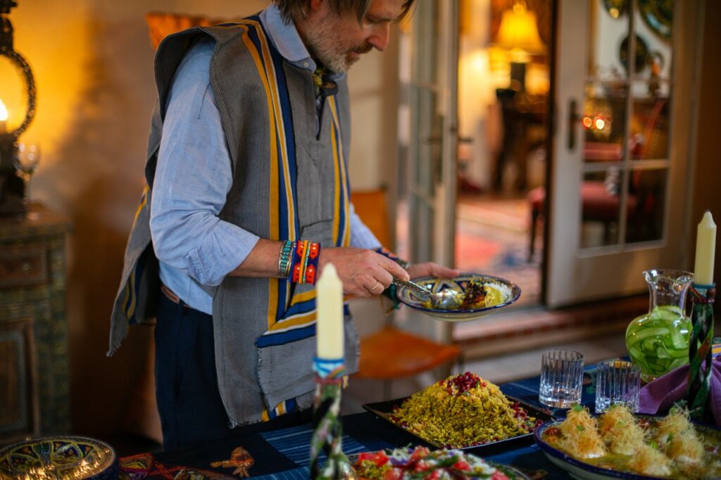 A man scoops rice onto a blue plate.
