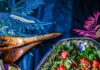 How the International Folk Art Market Is Preserving Indigenous Textile Traditions A container of salad with tomatoes on top sits on a dark blue pattern textile.