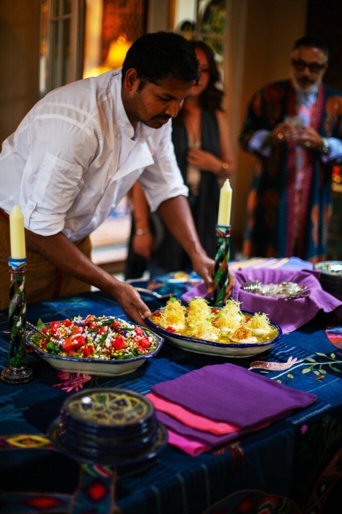 A chef pushes out a dish to serve at a buffet style dinner.