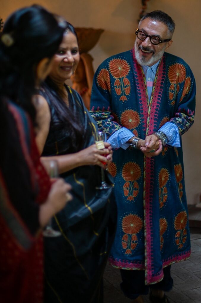 Two women and a man in long textile coverings talk to each other.