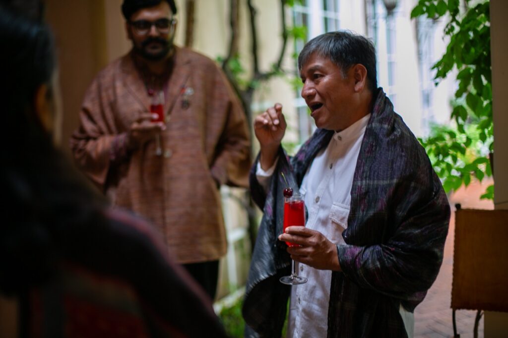 A man with a champagne glass talks to others.