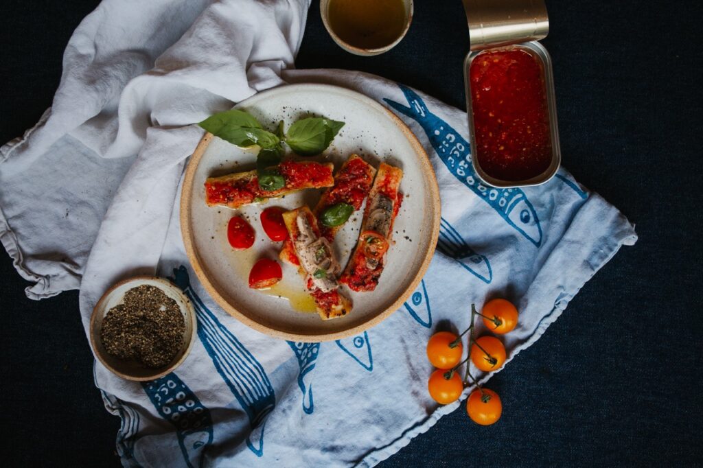 A plate of food with red jam sitting on a blue and white blanket.