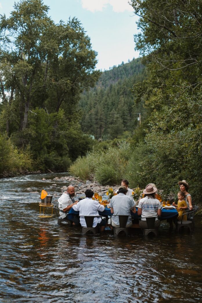 Picnicking in the Pecos River with Field Trip TABLE Magazine 2 A group of people eat at a table in the Pecos River river.