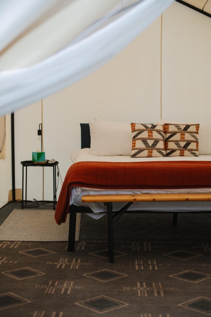 A tent bedroom with a red bedspread.