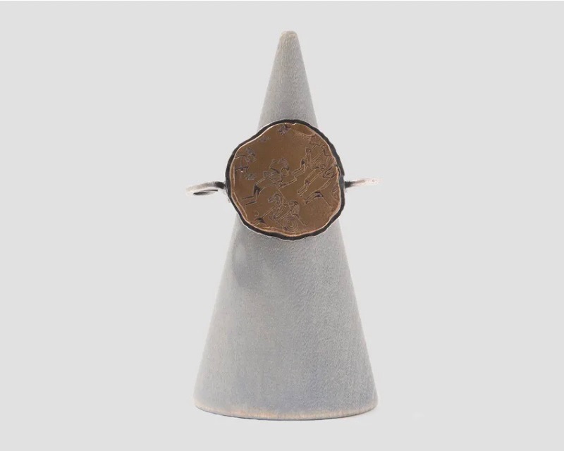 A brown wood ring on a white holder.