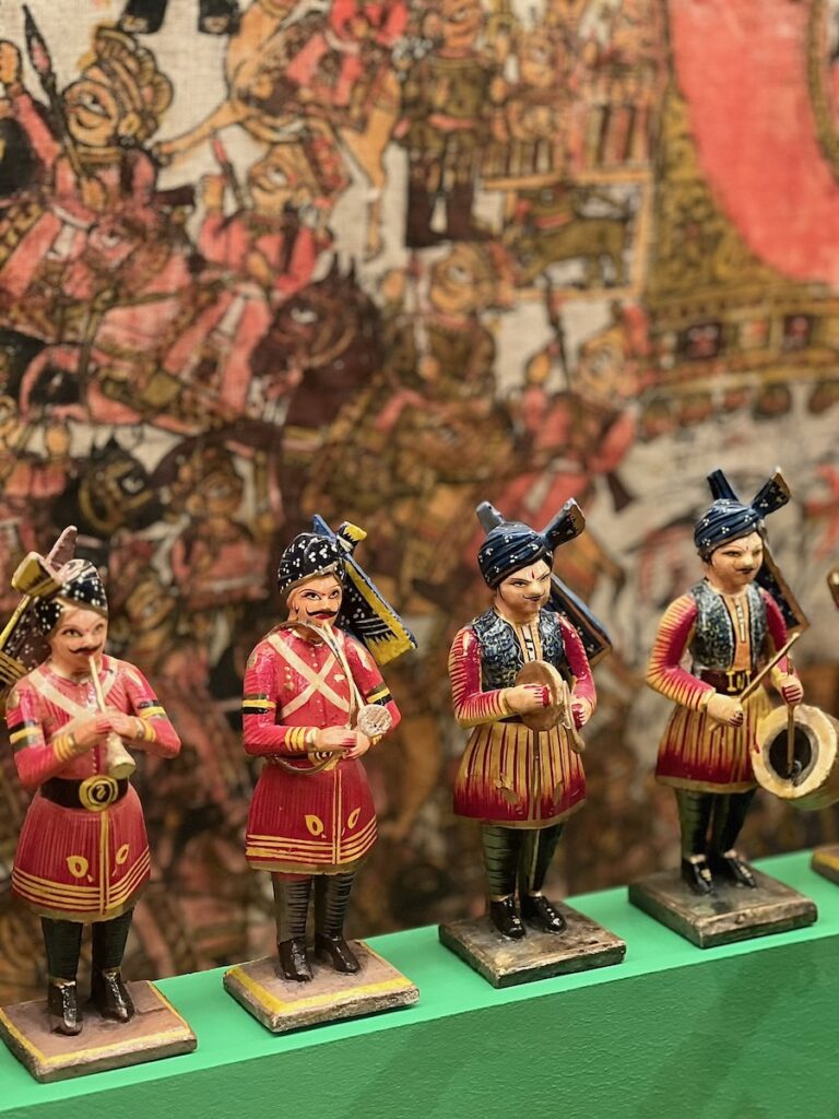 Four marching band members statues on a green table.