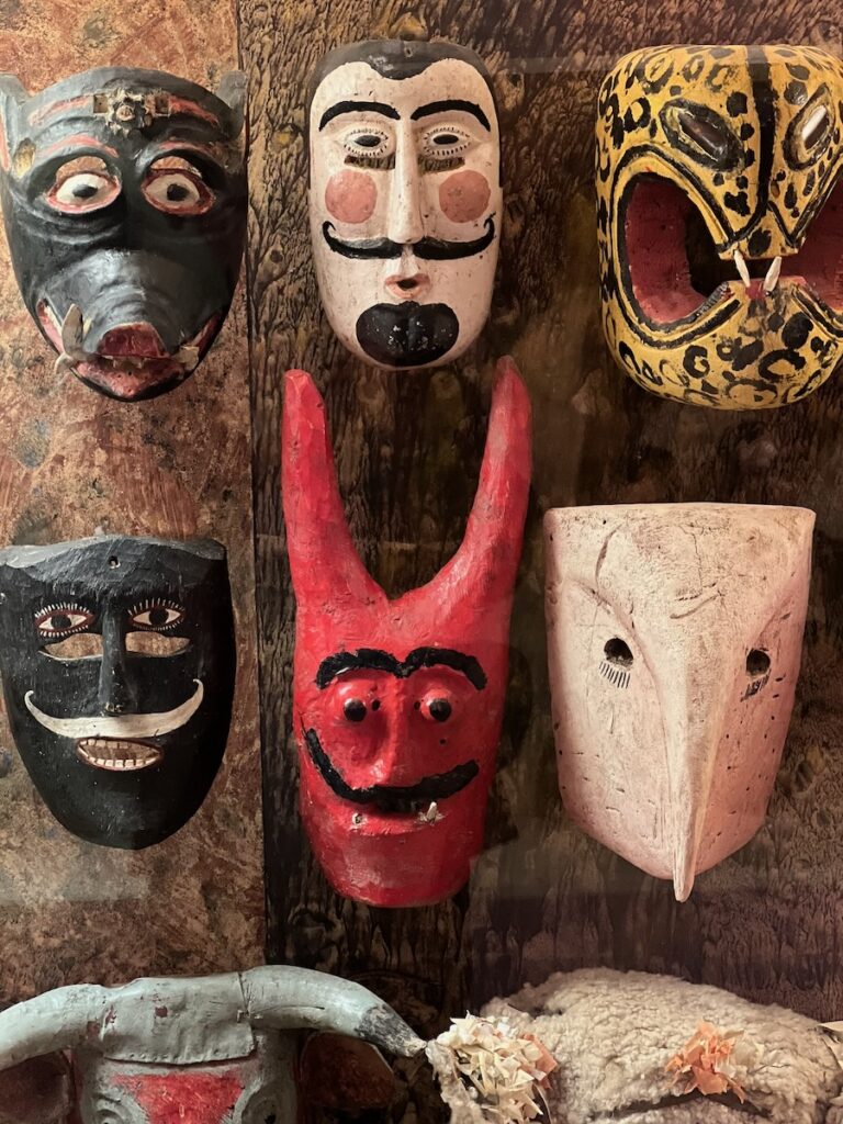 Six folk masks in various colors and expressions.