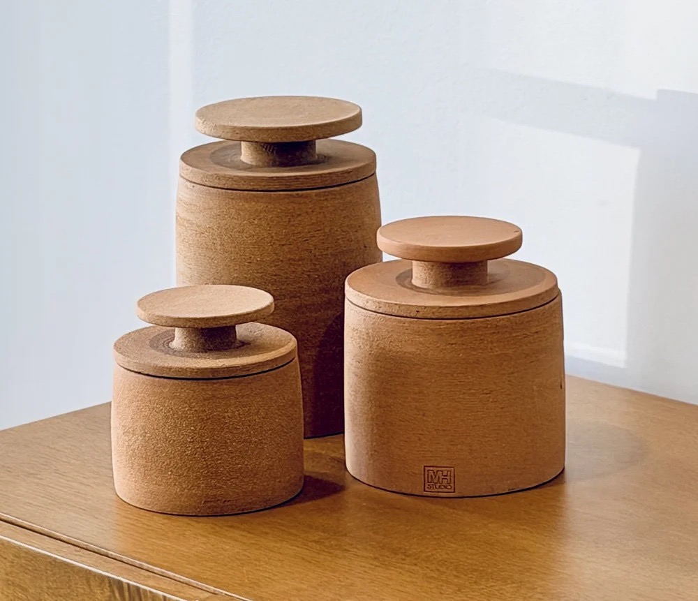 Three clay jars of varying sizes in brown.
