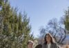 Behind the Scenes of Bringing the World to the 2026 International Folk Art Market Two women from the International Folk Art Market lean against a rock outside in Santa Fe.