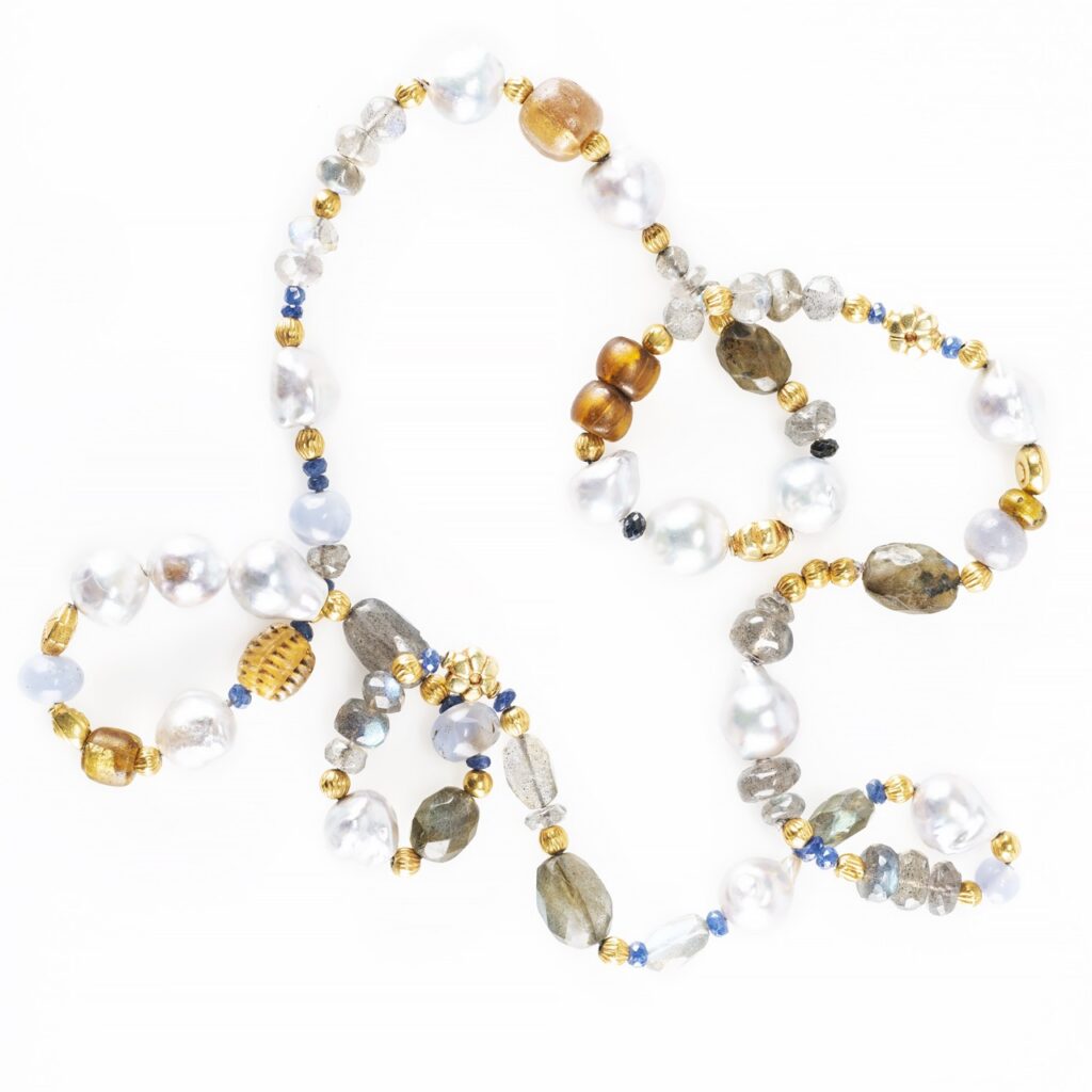 A necklace with white, gold, and brown beads and pearls.