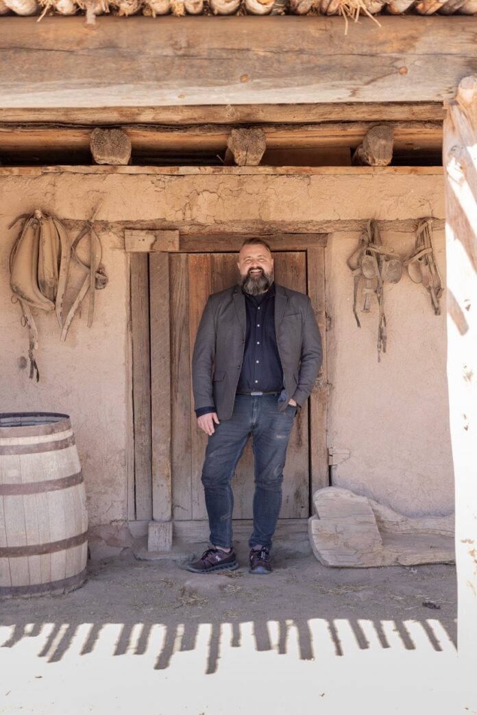 Take a Visit to El Rancho de las Golondrinas 2 TABLE Magazine A man stands outside a historic building in El Rancho de las Golondrinas.