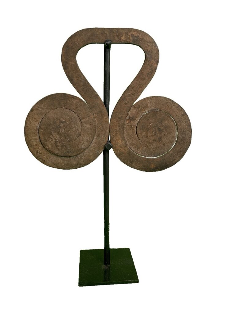 A sculpture on a stick with swirling metal sides.