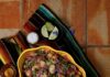 Bean Salad A yellow swiggly bowl with a Bean Salad inside beside little dishes of spices and limes.