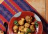 Green Chile Hushpuppies A red plate with white dots and Green Chile Hushpuppies on it and a red and purple cloth under the plate.