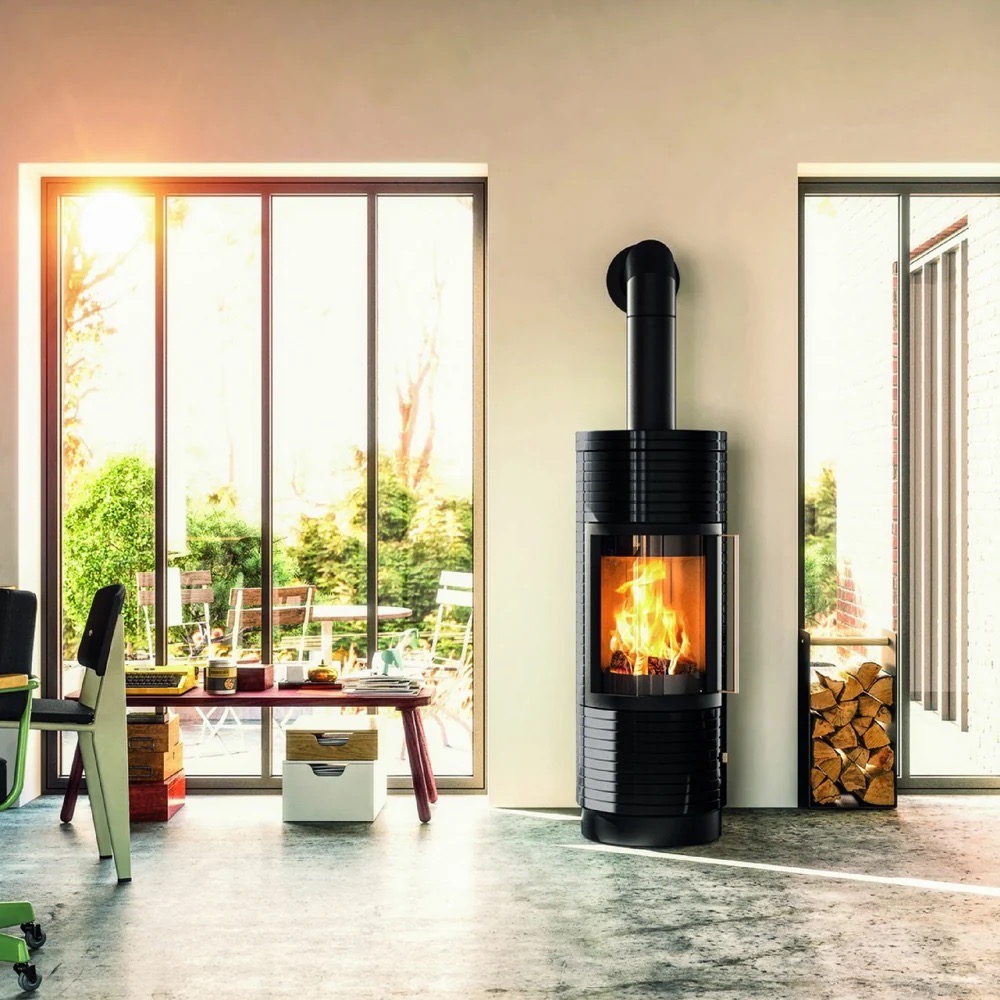 A black fire kettle stove against a wall between two sliding doors to outside.