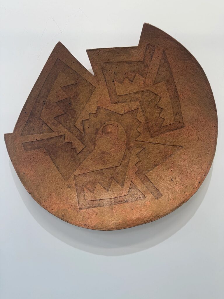 A brown plate that's jagged on the edge and had ink prints on it.
