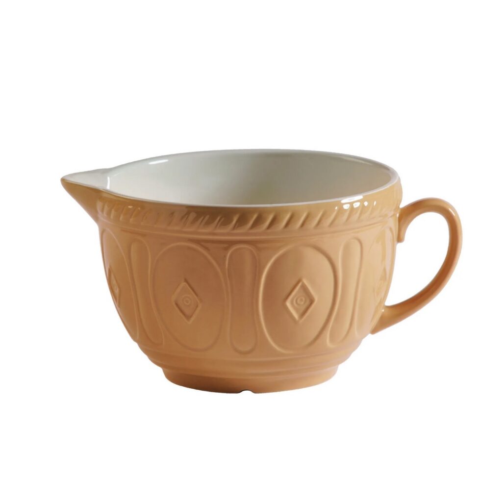A cream colored mixing bowl with a spout and handle.