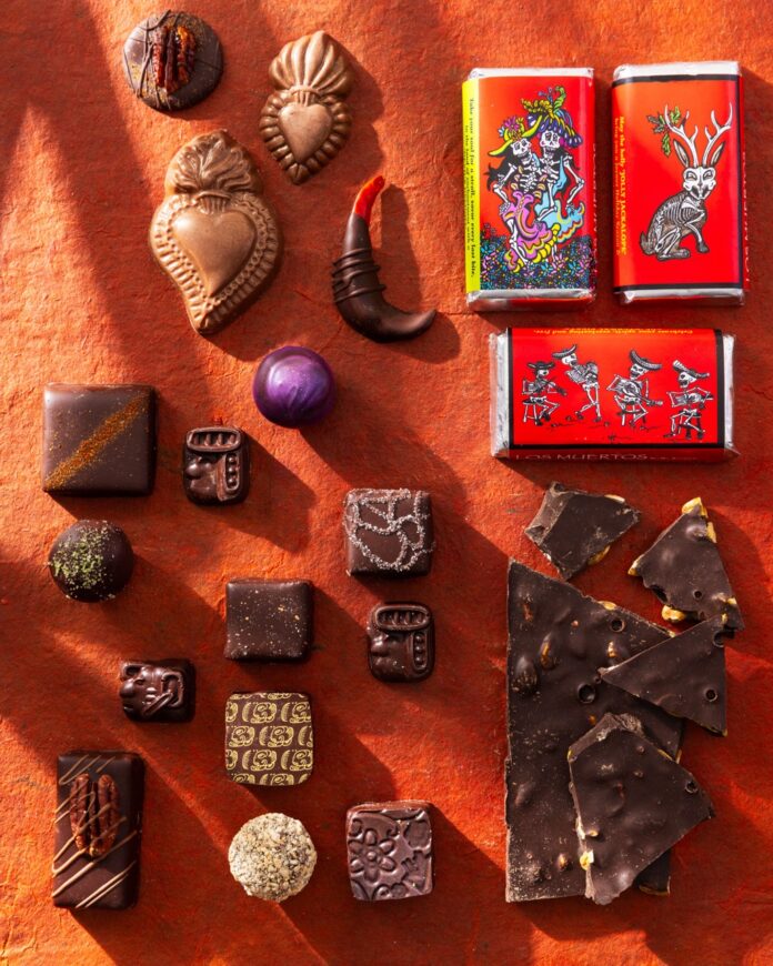 Various pieces of chocolate on an orange background with chocolate bark and little bars.
