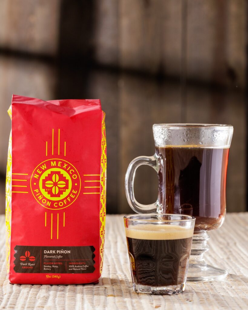 A red bag of coffee beside a shot of espresso and a glass of coffee.