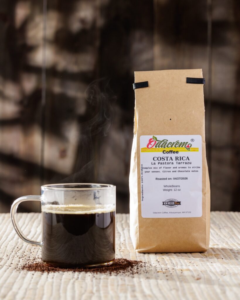 A cup of coffee beside a brown bag of coffee.