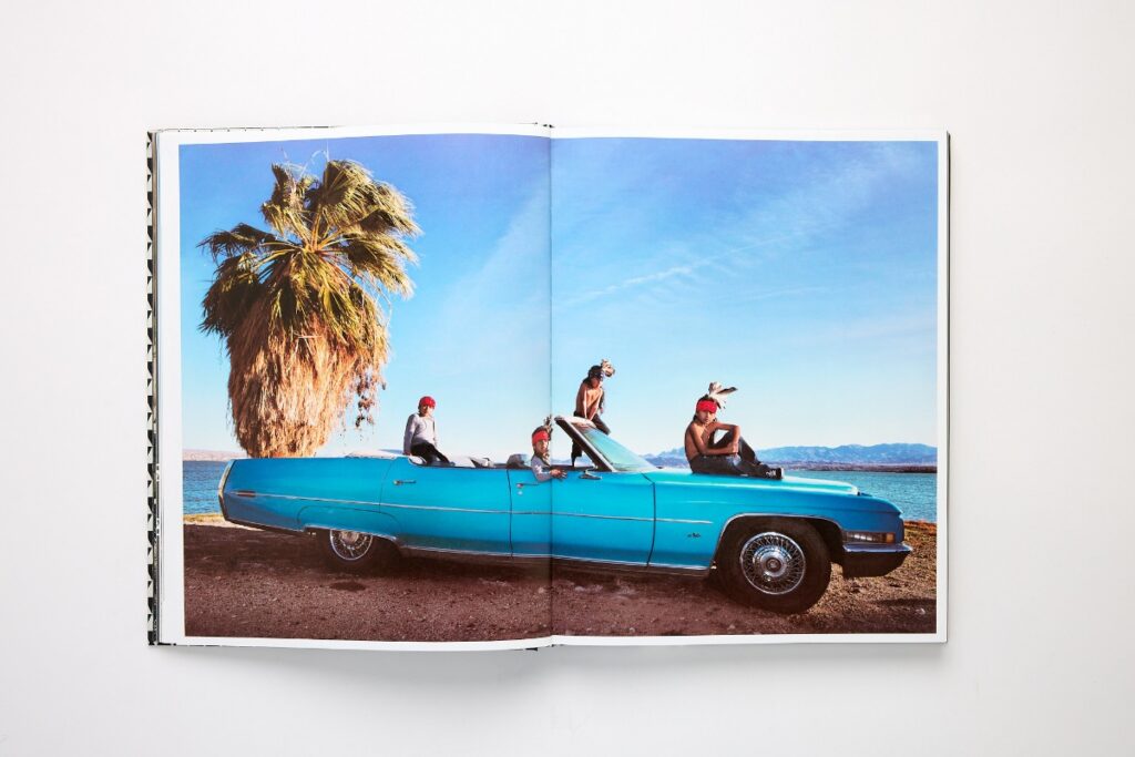 Open Radius Books art monograph featuring photography of people sitting on a vintage blue convertible car.