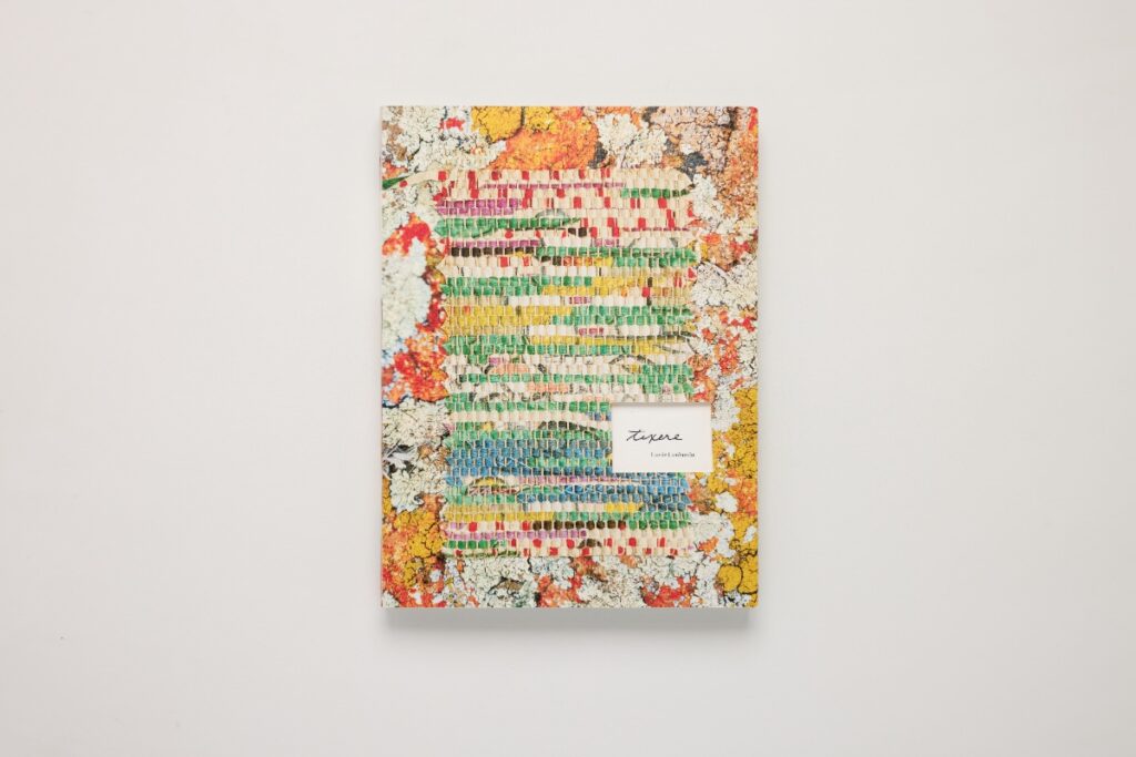 Cover of the art book tēxēre by Laurie Lambrecht, featuring a textured textile artwork design.