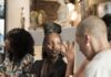 Vanna Curated Living in Santa Fe: Where Art, Culture & Community Meet Medium shot of gallery owner Nelly-Joy Irakoze gesturing and talking animatedly with guests at the dinner table.
