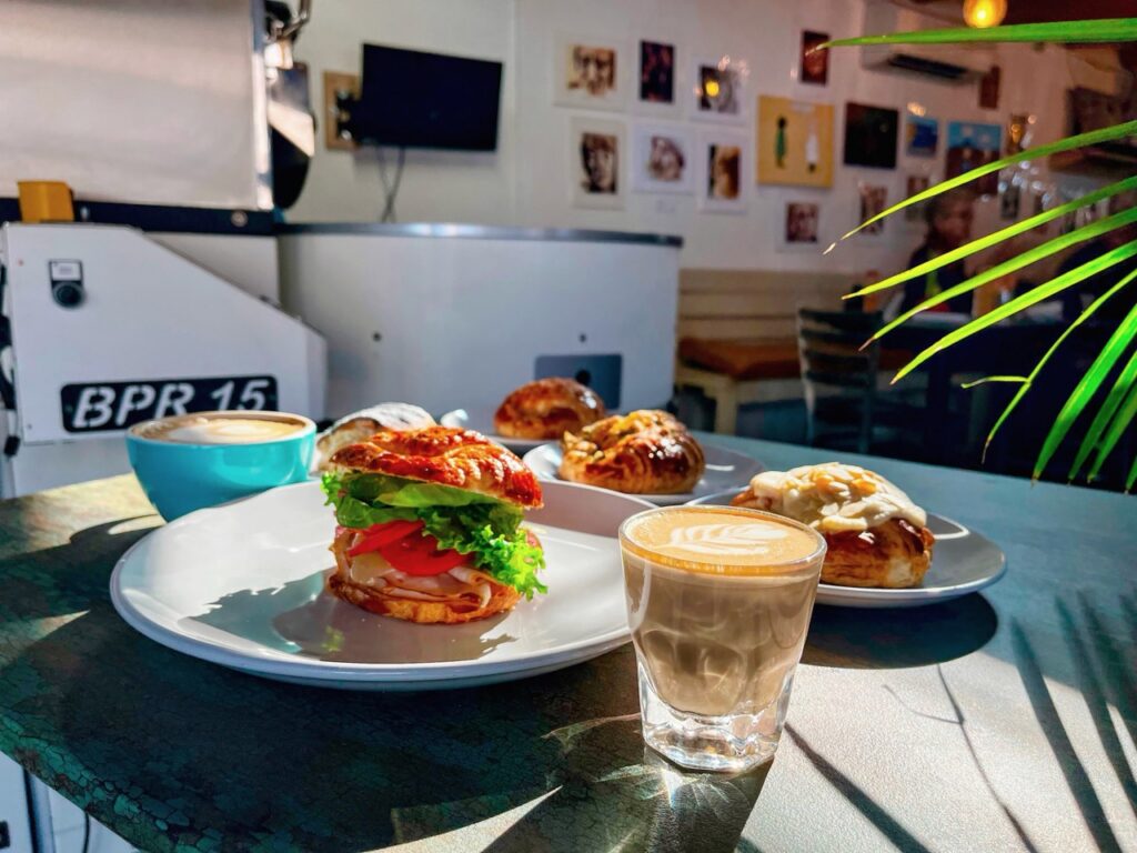 A spread of sandwiches next to a glass of coffee.