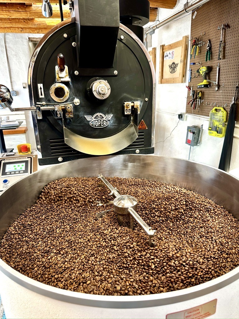A large coffee bean vat with a mixer in it.